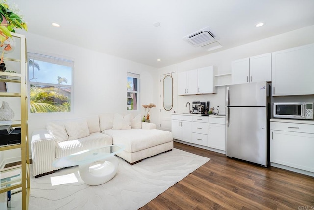 living area with dark wood-type flooring, recessed lighting, and visible vents