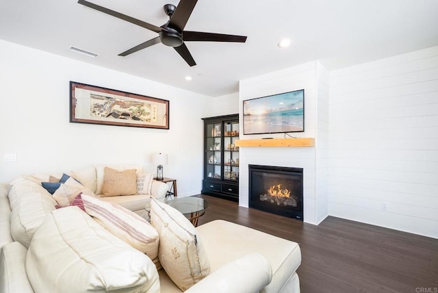 living area with visible vents, a large fireplace, ceiling fan, dark wood-type flooring, and recessed lighting