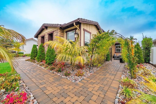 view of side of property featuring a tile roof and fence