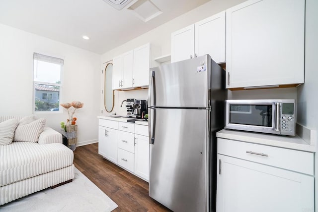 kitchen with dark wood-type flooring, light countertops, recessed lighting, stainless steel appliances, and white cabinetry