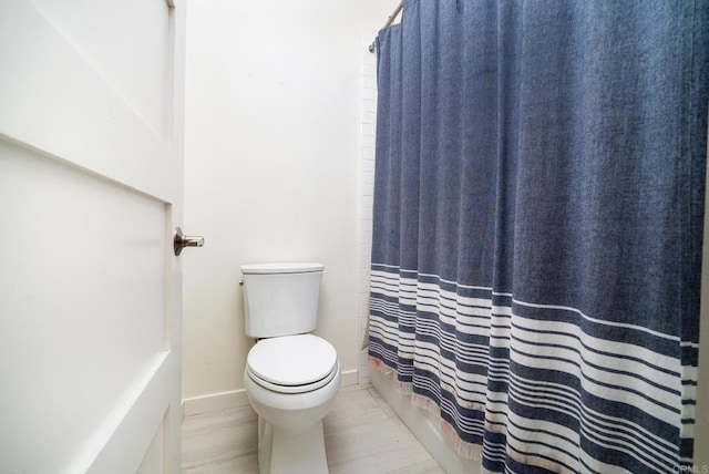 bathroom featuring toilet and baseboards