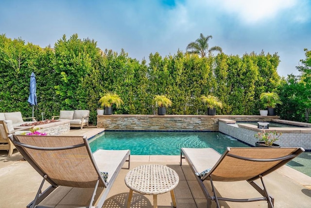 pool featuring an in ground hot tub and a patio area