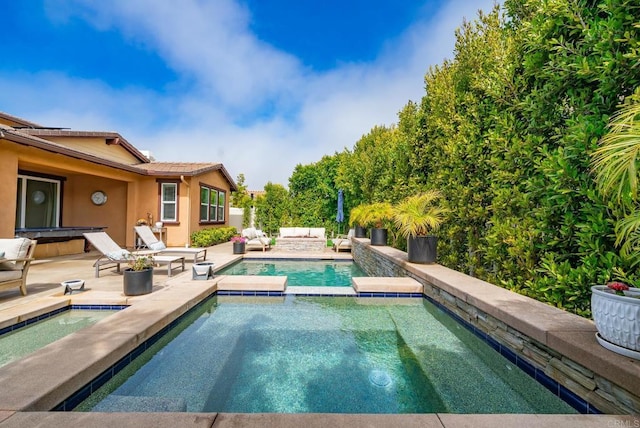 view of pool with a fenced in pool, a patio, and an in ground hot tub