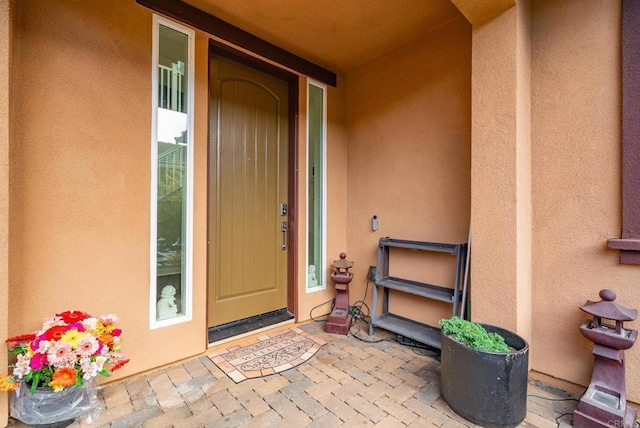 property entrance with stucco siding