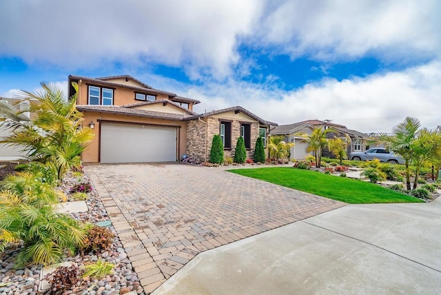 view of front of property featuring stucco siding, a front lawn, stone siding, a tile roof, and decorative driveway