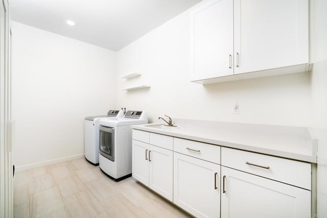 laundry room featuring washing machine and clothes dryer, baseboards, recessed lighting, cabinet space, and a sink