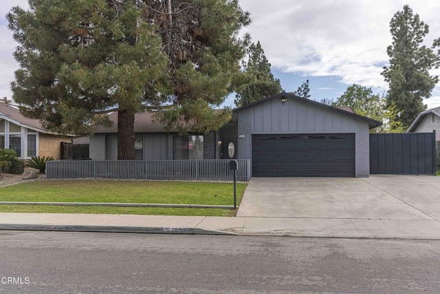 ranch-style house featuring a fenced front yard, a front lawn, concrete driveway, and a garage