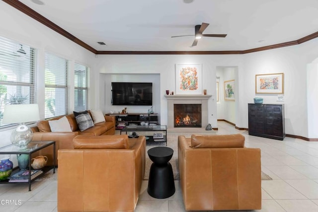 living area with baseboards, light tile patterned flooring, ceiling fan, and crown molding