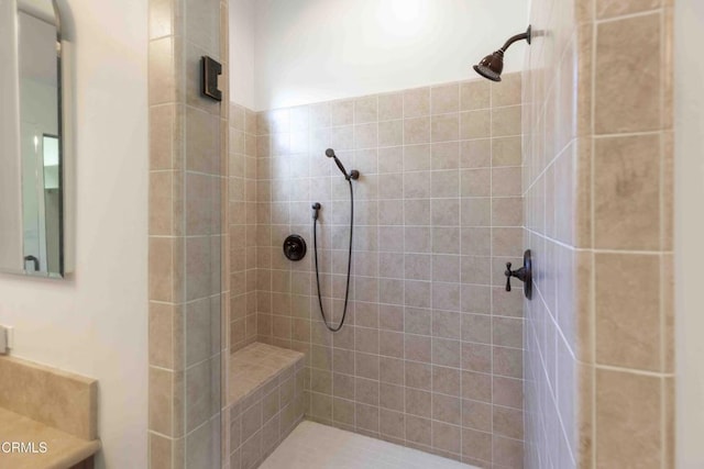 bathroom with vanity and a tile shower