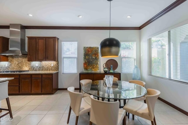 dining room featuring light tile patterned floors, crown molding, and baseboards