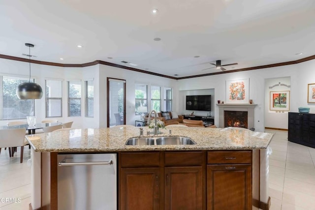 kitchen featuring light stone counters, open floor plan, and a sink