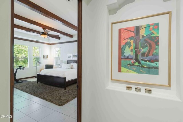 bedroom with beamed ceiling, a ceiling fan, and tile patterned flooring