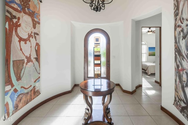 entryway with tile patterned floors, baseboards, and arched walkways