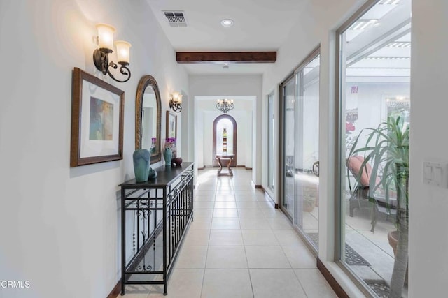 corridor with visible vents, beamed ceiling, light tile patterned floors, arched walkways, and a notable chandelier