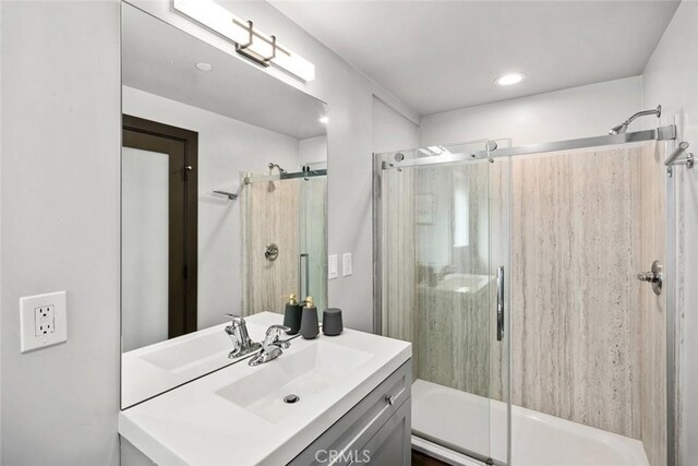 full bathroom featuring recessed lighting, an enclosed shower, vanity, and a washtub