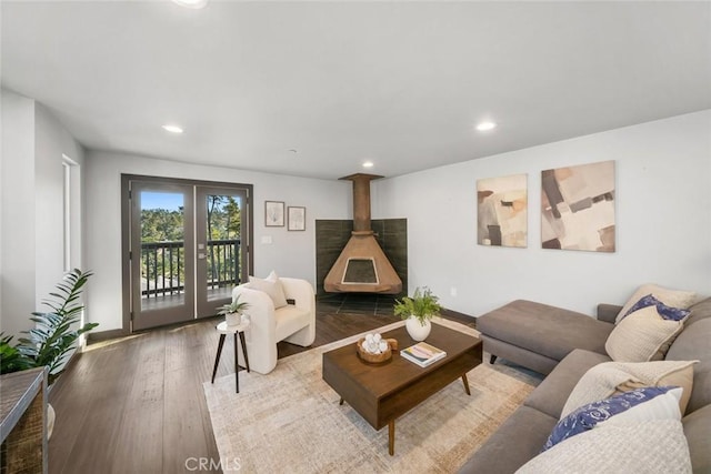 living room featuring hardwood / wood-style flooring, a wood stove, and recessed lighting