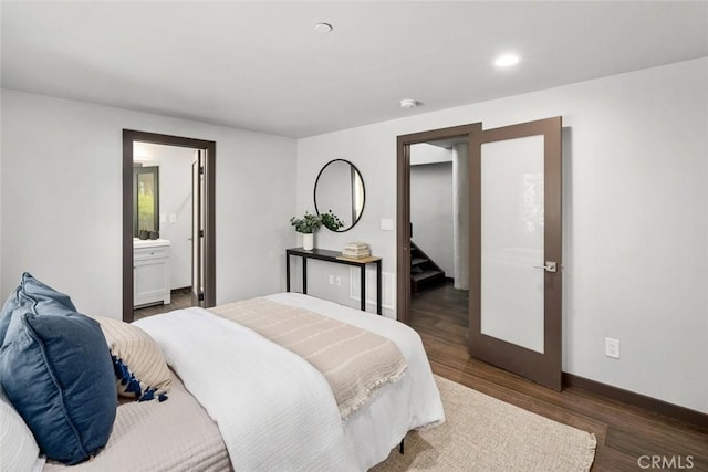 bedroom featuring recessed lighting, wood finished floors, baseboards, and ensuite bathroom