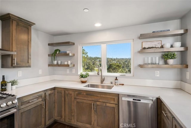 kitchen with a sink, stainless steel appliances, light countertops, and open shelves