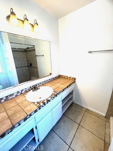 bathroom featuring tile patterned floors, curtained shower, and vanity