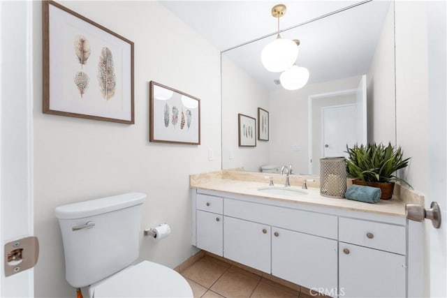 bathroom featuring tile patterned floors, baseboards, toilet, and vanity