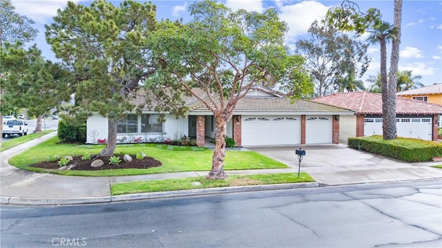 ranch-style home with concrete driveway, a front yard, an attached garage, brick siding, and a tiled roof