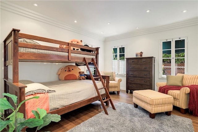 bedroom featuring crown molding, multiple windows, and wood finished floors