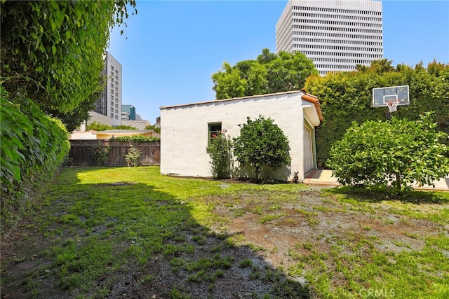 view of yard with an outbuilding, central AC unit, and fence