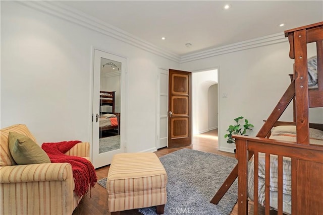 bedroom with crown molding, baseboards, recessed lighting, wood finished floors, and arched walkways