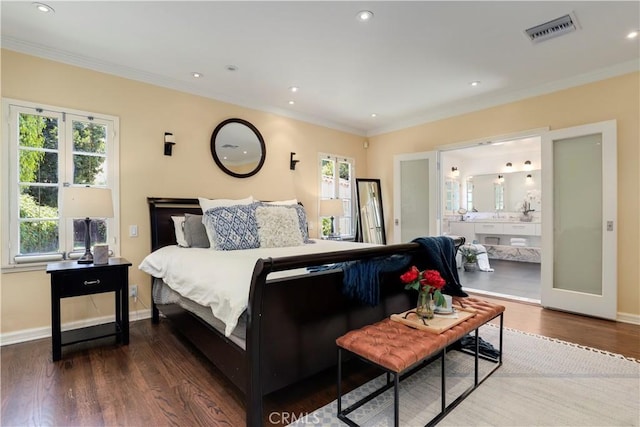 bedroom with visible vents, baseboards, wood finished floors, and ornamental molding