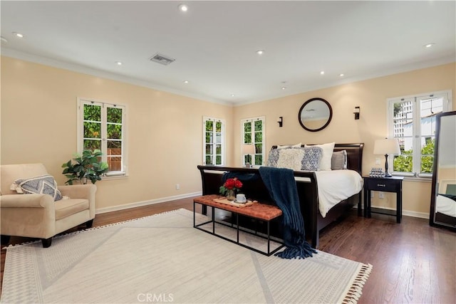 bedroom featuring crown molding, wood finished floors, and visible vents