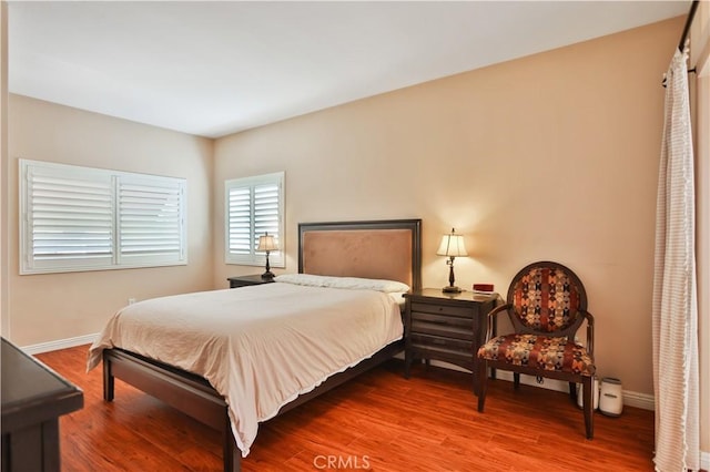 bedroom with baseboards and wood finished floors