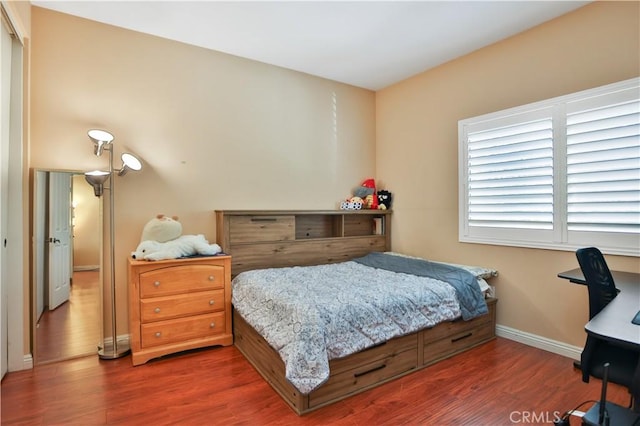 bedroom with baseboards and wood finished floors