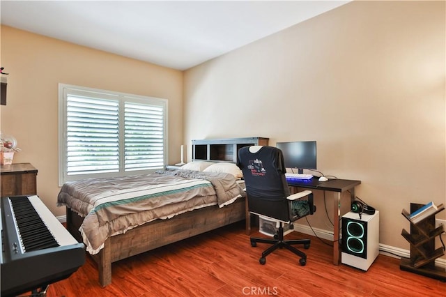 bedroom with wood finished floors and baseboards