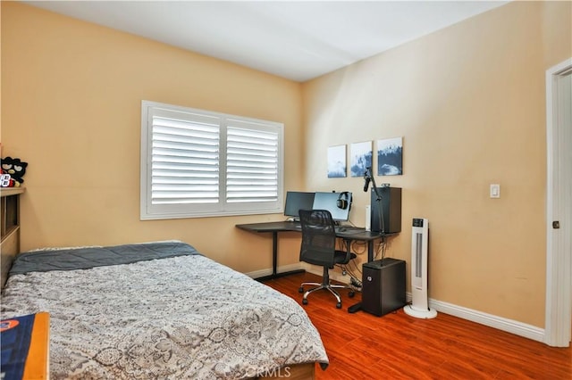 bedroom featuring wood finished floors and baseboards