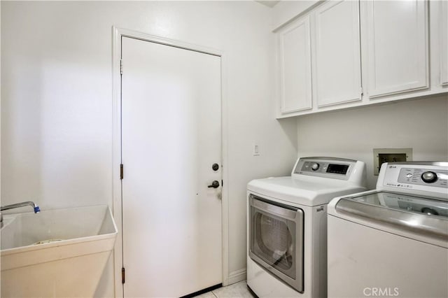 laundry room with a sink, cabinet space, and washer and clothes dryer