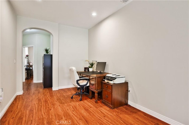 office area featuring arched walkways, recessed lighting, light wood finished floors, and baseboards