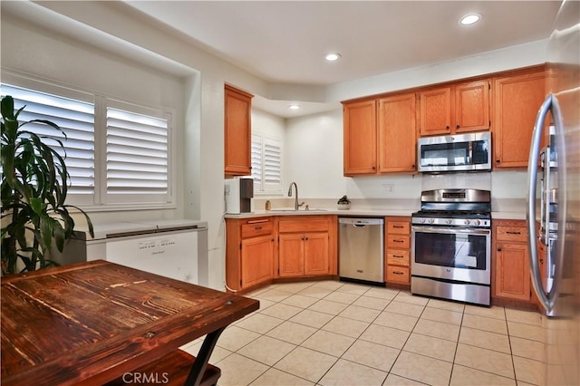 kitchen with a sink, light countertops, recessed lighting, and stainless steel appliances