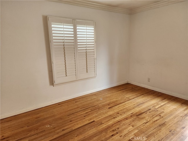 empty room with light wood-style flooring, baseboards, and ornamental molding