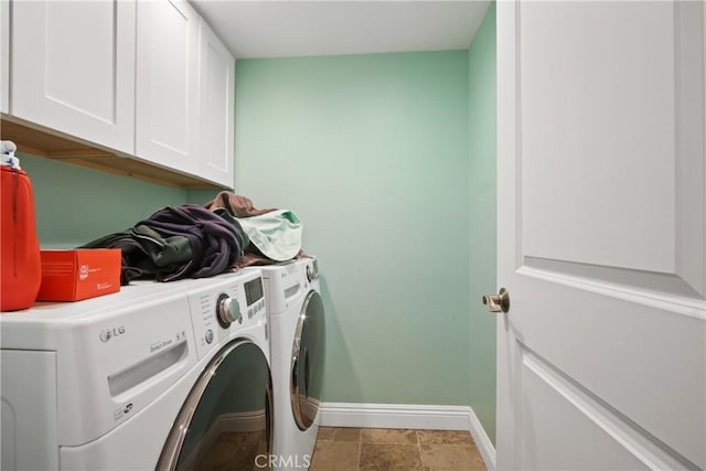 laundry area featuring baseboards, cabinet space, and washing machine and clothes dryer