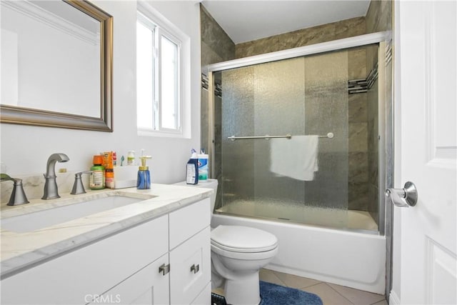 full bath with shower / bath combination with glass door, toilet, vanity, and tile patterned flooring