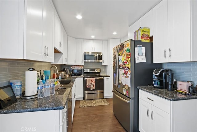 kitchen with a sink, dark wood-style flooring, white cabinetry, and stainless steel appliances