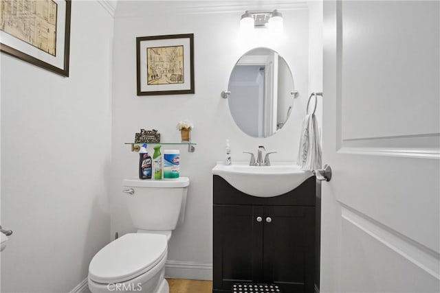 half bath with toilet, vanity, and baseboards