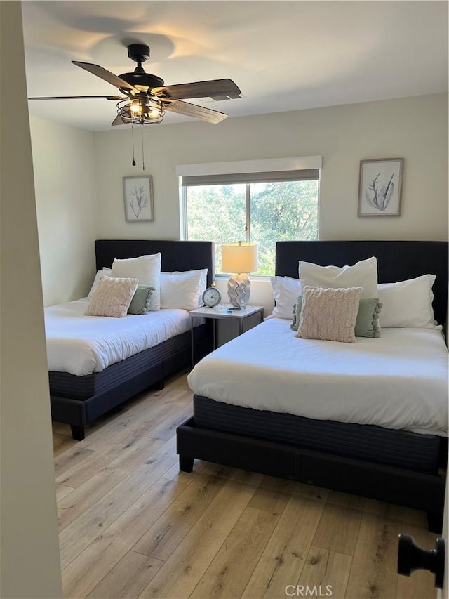 bedroom with light wood-type flooring and a ceiling fan