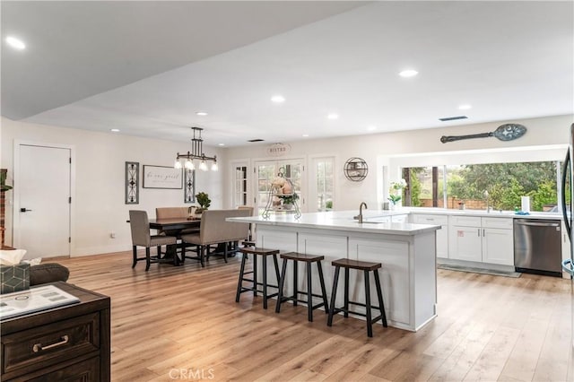 38680 Mesa Rd, Temecula, CA 92592 - kitchen featuring stainless steel dishwasher, white cabinets, light countertops, recessed lighting, and a kitchen breakfast bar