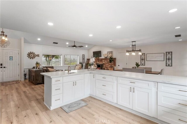 38680 Mesa Rd, Temecula, CA 92592 - kitchen featuring a sink, open floor plan, a fireplace, light wood-type flooring, and hanging light fixtures