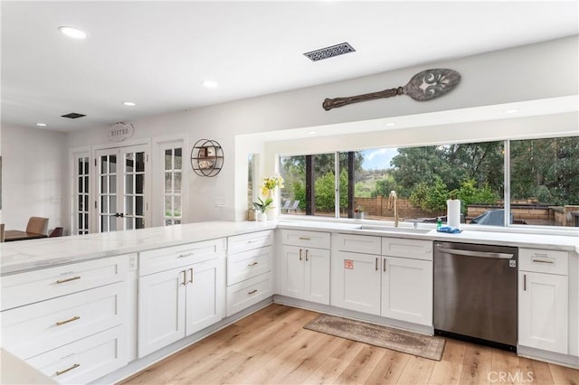 38680 Mesa Rd, Temecula, CA 92592 - kitchen with stainless steel dishwasher, a sink, white cabinetry, light stone counters, and light wood-type flooring