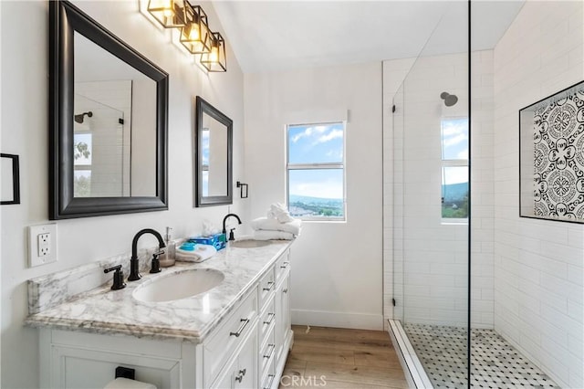 38680 Mesa Rd, Temecula, CA 92592 - bathroom featuring double vanity, a tile shower, wood finished floors, and baseboards