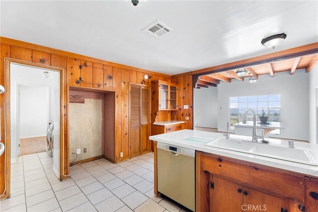 kitchen featuring visible vents, beam ceiling, a sink, stainless steel dishwasher, and washer and clothes dryer