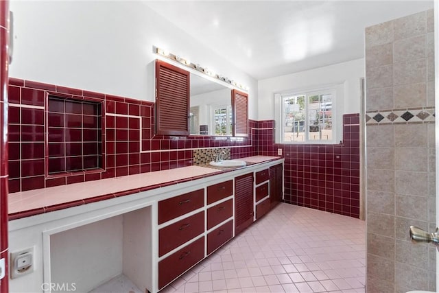 bathroom with tile patterned floors, wainscoting, tile walls, and vanity