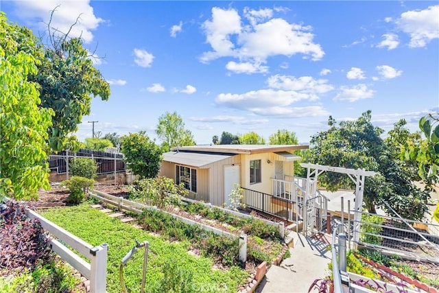 view of front of house with a garden and fence